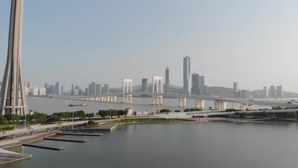 Drone approach shot of traffic crossing Sai Van Bridge in Macau and base of Macau Tower