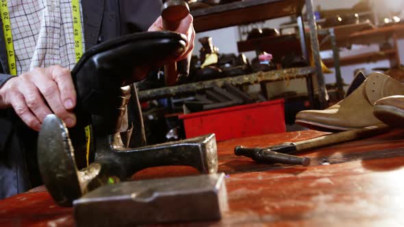 Shoemaker hammering on a shoe