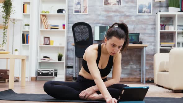 Attractive Woman Searching Yoga Exercises on Tablet