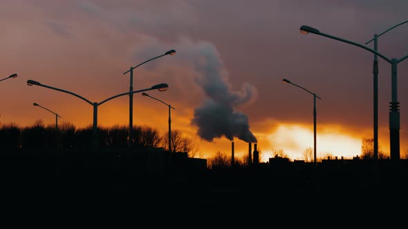 Industrial Zone From City Pipe Thick Smoke is Poured From Factory Sunny Evening Cityscape