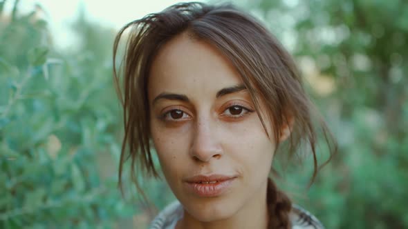 Closeup of Hippie Brunette Woman Natural Human Face with Tunned Skin Calm Look at Camera Open and