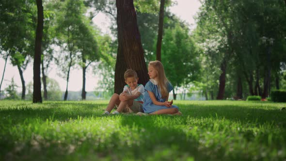 Happy Children Seat Near Tree on Green Grass