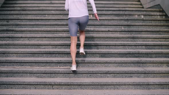 Woman Athlete Running Up Steps
