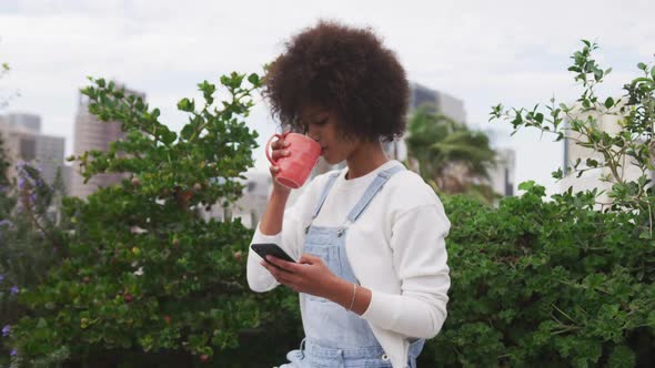 Mixed race woman drinking coffee on rooftop