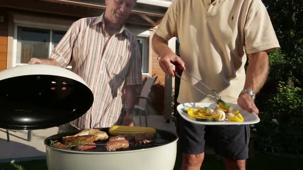 Senior Men Cooking on Barbecue Grill