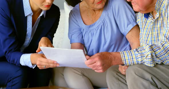 Front view of old Caucasian senior couple interacting with real estate agent at home 4k