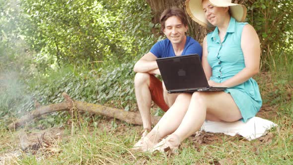 A Family in the Woods Communicates Via Video Link Using a Laptop