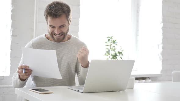 Excited Businessman Celebrating Results While Reading Documents Letter