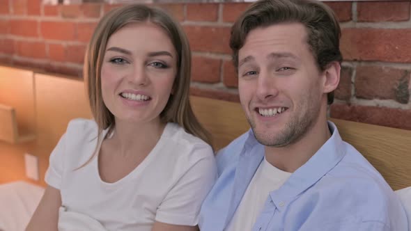 Portrait of Young Couple Doing Video Chat in Bed