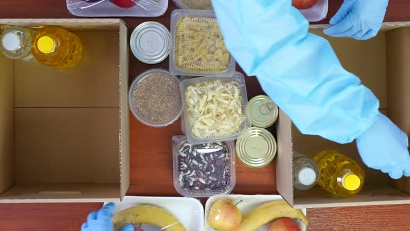 Top View, Close-up, Volunteers in Protective Gloves, Suits Pack Grocery To Cardboard Donation Boxes