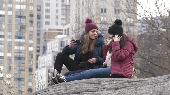 Two Girls Sit on a Rock in Central Park New York
