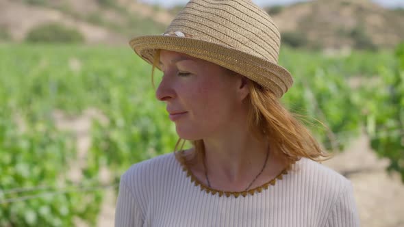 Positive Young Caucasian Woman Standing at Winery Plantation Looking Away Smiling