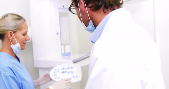 Smiling dentist talking to dental assistant