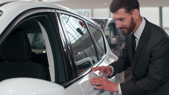 Nice Man Planning To Buy Car, Young Man Carefully Viewing Model, Inspecting Side Door and Glass