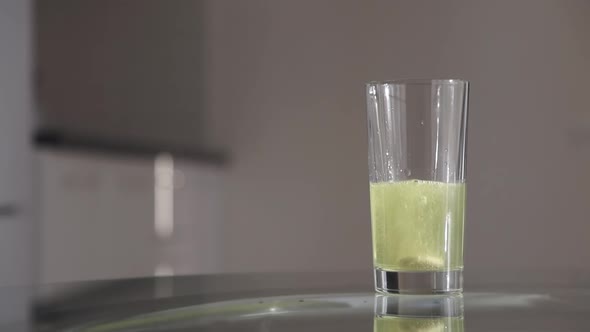 Effervescent tablet dissolve slowly in a transparent glass of water, Slow motion