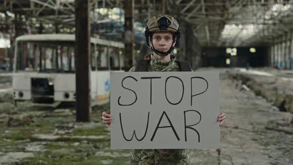 Military Woman Holding Stop War Banner in Hands