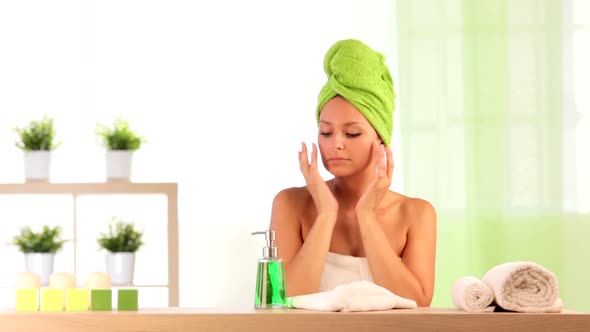 Woman Wearing Towels Applies Beauty Treatment at Health Spa Indoor