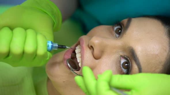 Dentist Using Blue Gel on Tooth, Modeling Paste, Cosmetic Dentistry, Closeup