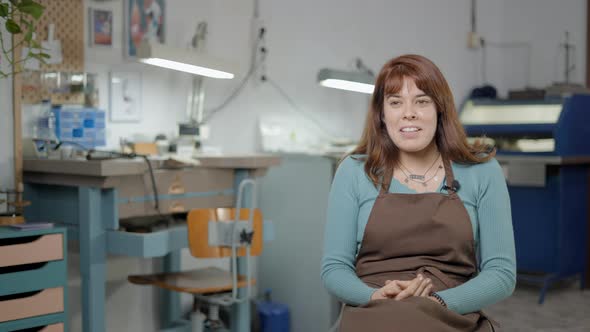 Artisan Jeweler In Brown Apron Being Interviewed At Her Workshop