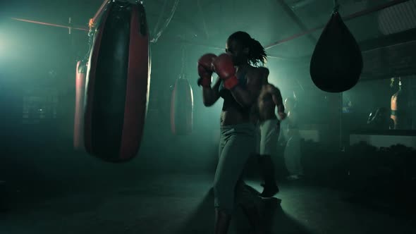 Group of Boxers Training in a Group. Female in the foreground.Male skipping in the background