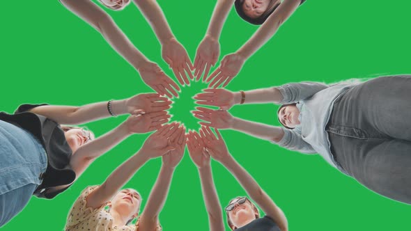 Joyful Girls Pull Their Palms to the Center on a Green Background