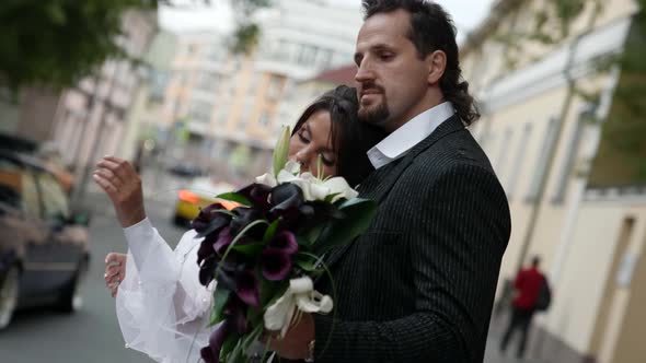 Embrace of Groom and Bride in City Man is Hugging His Wife on Street in Wedding Day