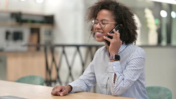 Cheerful African Businesswoman Talking on Smartphone in Office 