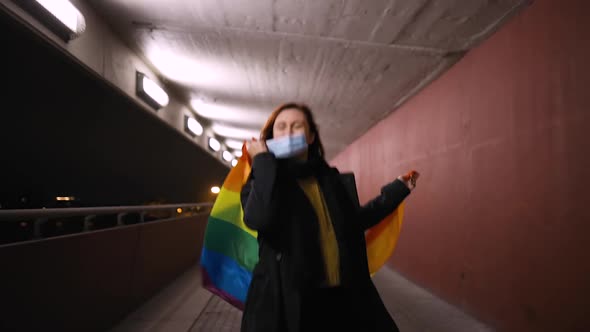 Happy Lesbian Woman Takes Off Medical Mask Holding Large Rainbow Flag