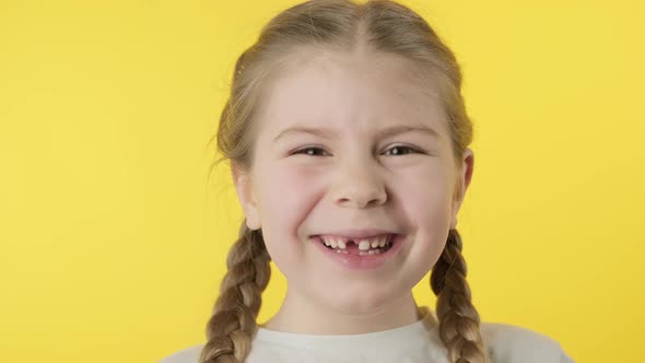 Little Toothless Girl 67 Years Old Smiling at Yellow Background