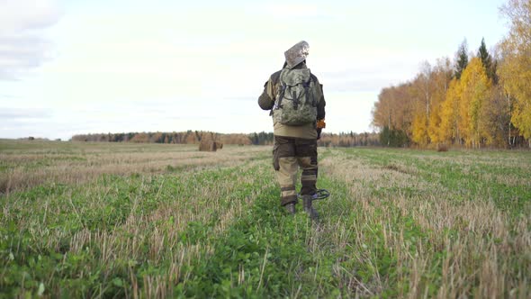 Man Treasure Hunter in the Field Searching with Metal Detector