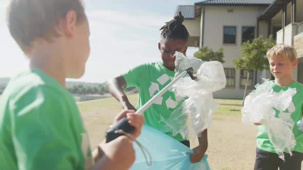 Video of diverse boys picking up trashes in front of school