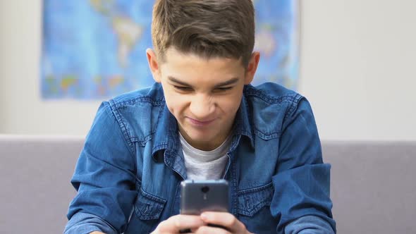 Stressed School Boy Finally Winning in Video Game on Smartphone, Leisure Time