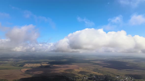 Aerial View From Airplane Window at High Altitude of Earth Covered with White Puffy Cumulus Clouds