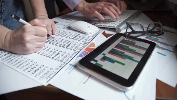 Two Young Businessmen Using Touchpad at Meeting