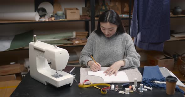 Professional Young Female Tailor Working in Workshop