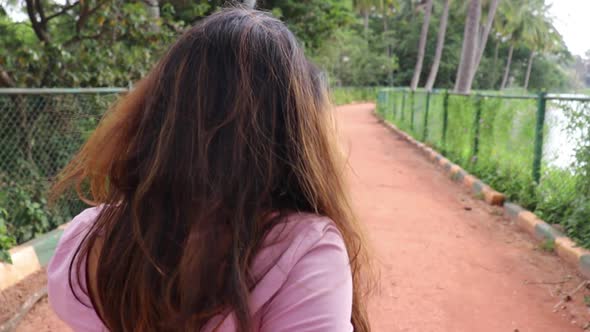 POV shot of a of beautiful Indian woman holding hands with her boyfriend walking forward.