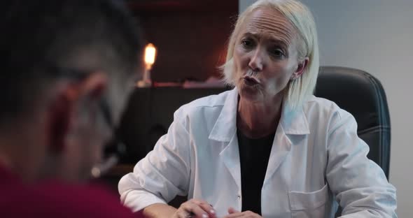 Female doctor showing emphaty towards patient while touching his hand