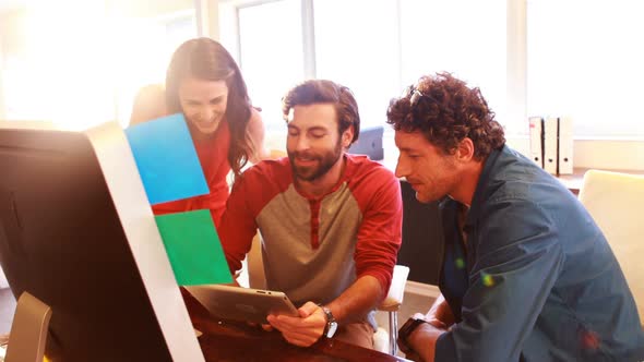 Group of graphic designers interacting while using digital tablet