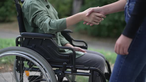 Side View Unrecognizable Disabled Caucasian Girl Greeting Friend Shaking Hands in Slow Motion