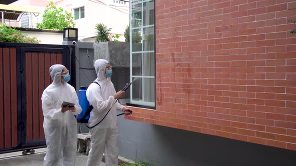 Man and women wear protective suits, goggles and masks making disinfection and decontamination 