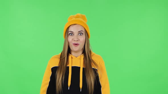 Portrait of Modern Girl in Yellow Hat Confused Saying Oops and Shrugging. Green Screen