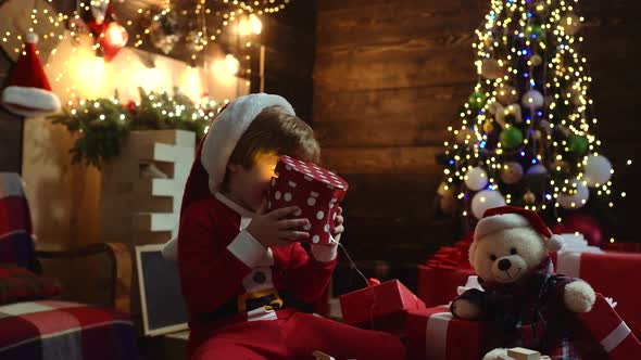 Happy Cute Child in Santa Hat with Present Have a Christmas. Merry Christmas and Happy Holidays