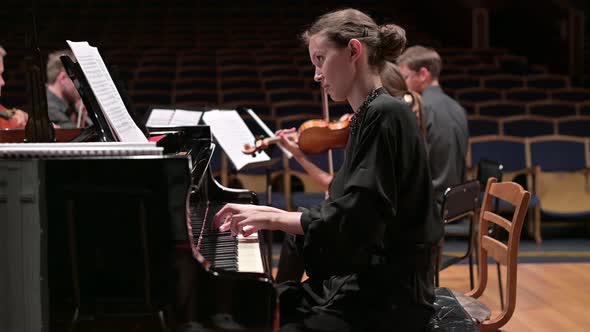 young woman playing piano with string quartet