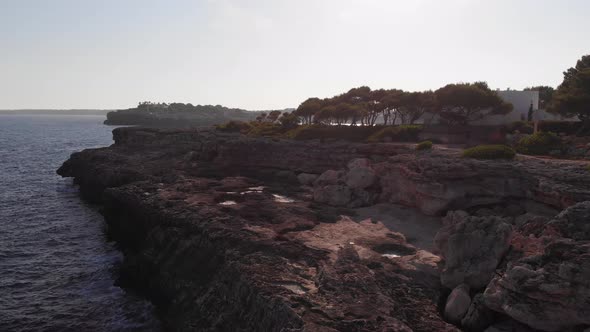 AERIAL: Flying close above cliffs of fissured coastline of Mallorca