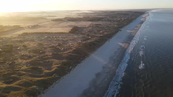 Aerial view of rolling waves and sunrise at the ocean close to Løkken by the North Sea, Denmark