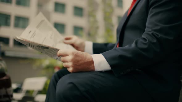 Businessman Senior in an Expensive Suit with a Beautiful Beard in Black Blue Jacket Sits on Bench in