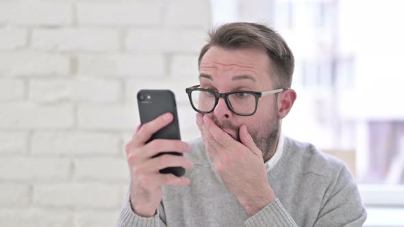 Shocked Creative Man Reacting To Loss on Smartphone