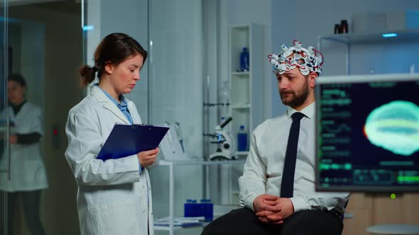 Man Sitting on Neurological Chair with Brainwave Scanning Headset