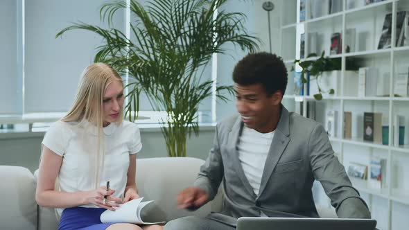 Black Man Sharing Good News with Coworkers