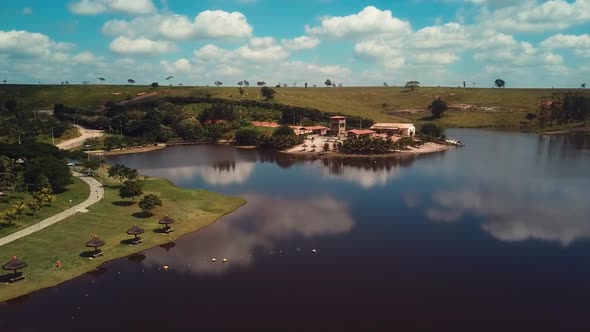 Aerial shot of flying over a lake next to a beautiful small village paradise